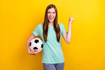 Photo of hooray brunette hairdo young lady hold ball wear teal t-shirt isolated on yellow color background