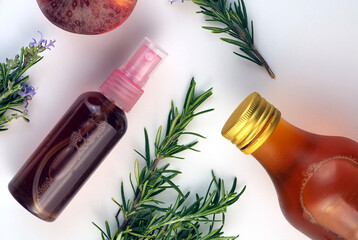 Rosemary and apple cider vinegar face toner in a bottle with spay, rosemary branches, apple cider...