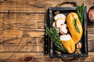 Hot Smoked chicken breast fillet meat on a wooden board with herbs. wooden background. Top view....