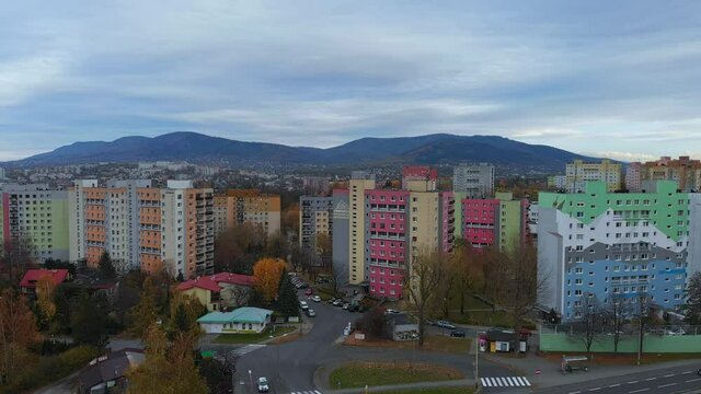 Fly over blocks of flats in Bielsko Biala City. Tilt up. View of mountains in background.