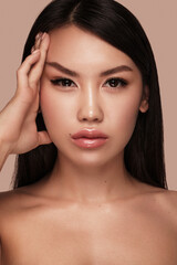 Fototapeta premium Beautiful delicate woman of oriental type with nude makeup and perfect skin. Beauty face. Spa