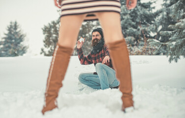 Play girl and man snowball fight in snowy forest. Christmas couple of happy man and woman. Couple in love in winter