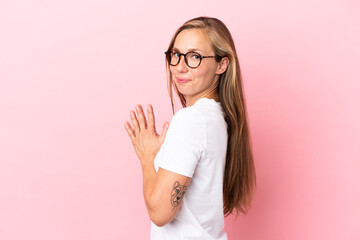 Young English woman isolated on pink background scheming something