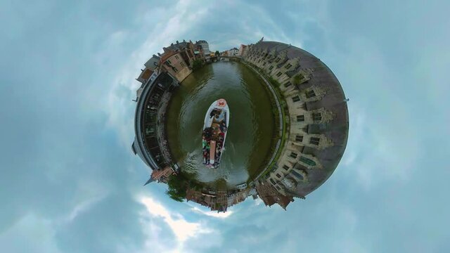 Little planet view of  riding a boat on a canal in the old town of the city Ghent in Belgium,.