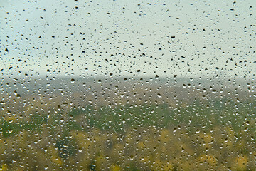 Many water drops on glass during rain, glass close up