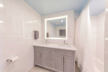 LED vanity mirror in a bathroom with white tile walls