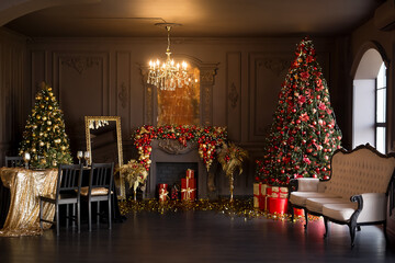 Interior of luxury dark living room with fireplace, comfortable sofa and chandelier decorated with Christmas tree and gifts