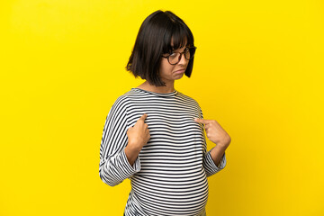 Young pregnant woman over isolated yellow background pointing to oneself