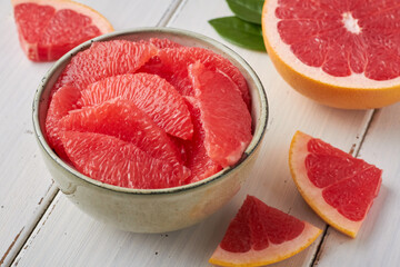 grapefruit pieces in a bowl on white background