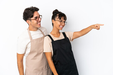 Restaurant mixed race waiters isolated on white background presenting an idea while looking smiling towards