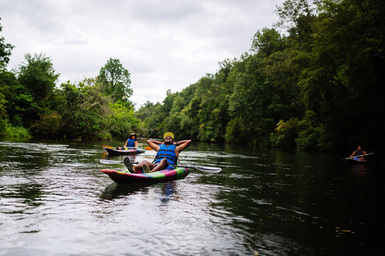 Relaxed man kayaking on calm river - Powered by Adobe