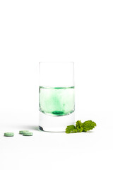 grüne Tablette, die sich in Wasser auflöst