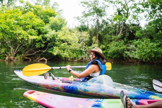 Smiling woman kayaking on calm river