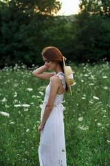 Fototapeta premium Woman in white dress flowers nature walk charm