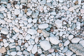 Sea pebbles on the beach. Close-up shot. Small and big roundish smooth stones. Texture of beach pebbles for a post, screensaver, wallpaper, postcard, poster, banner, cover, header for a website