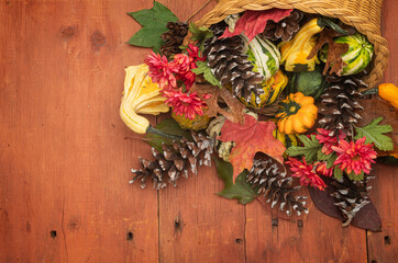 Cornucopia of gourds and pinecones on red barn wood