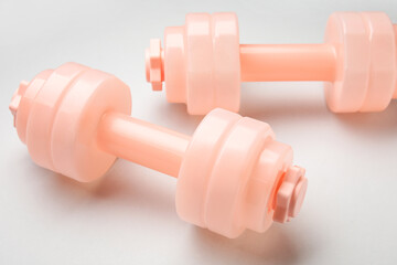 Pink dumbbells on light background