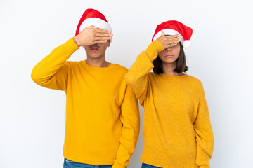 Young mixed race couple celebrating Christmas isolated on white background covering eyes by hands. Do not want to see something