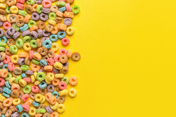 Crunchy corn flakes rings on color background