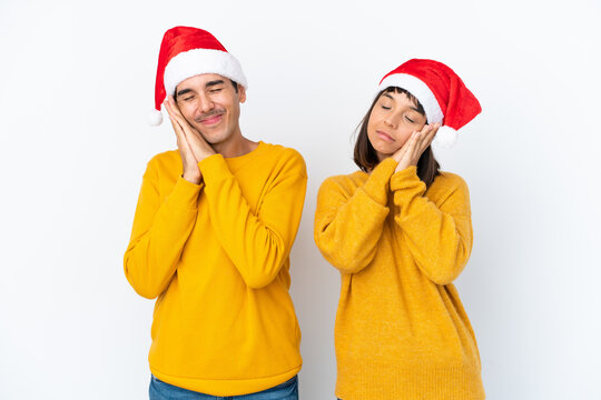 Young Mixed Race Couple Celebrating Christmas Isolated On White Background Making Sleep Gesture In Dorable Expression