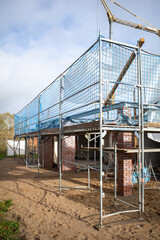 on the house wall there is scaffolding on a construction site