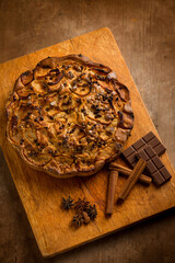 apple cake with cinnamon stick and chocolate over wood