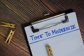Time To Modernize write on a paperwork isolated on Wooden Table.