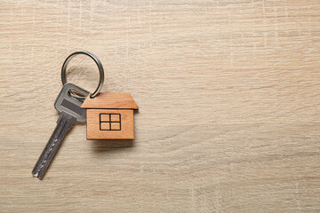 Fototapeta na wymiar House key with keychain on wooden background