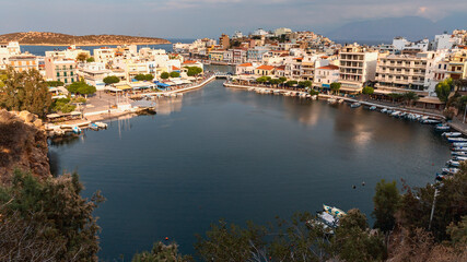view from the mountains to the quiet harbor with boats in the Greek resort town of Agios Nikolaos