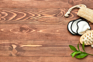 Reusable cotton pads, massage brush and loofah on wooden background