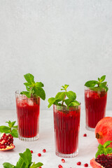 Refreshing pomegranate juice in glasses with mint and ice, cold drink