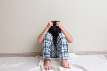 Teen boy in pajamas sitting on the floor