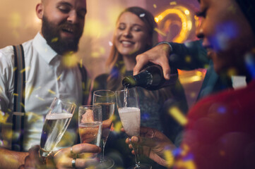 Friends celebrate New Year's Eve while drinking champagne