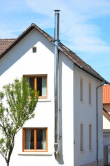 Schornstein, Außenkamin aus Edelstahl an der Fassade eines Wohnhauses