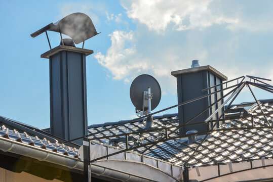 Neue metallverkleidete Schornstein- und Satellitenanlage an einem modernen Wohngebäude
