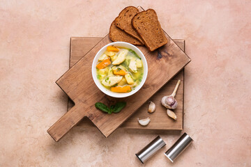 Bowl with delicious dumpling soup, bread and spices on color background