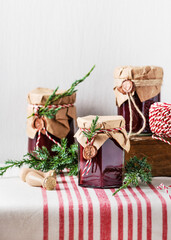 Handmade gift for Christmas. Homemade fruit jam in the jars decorated with grunge paper, wax seal...