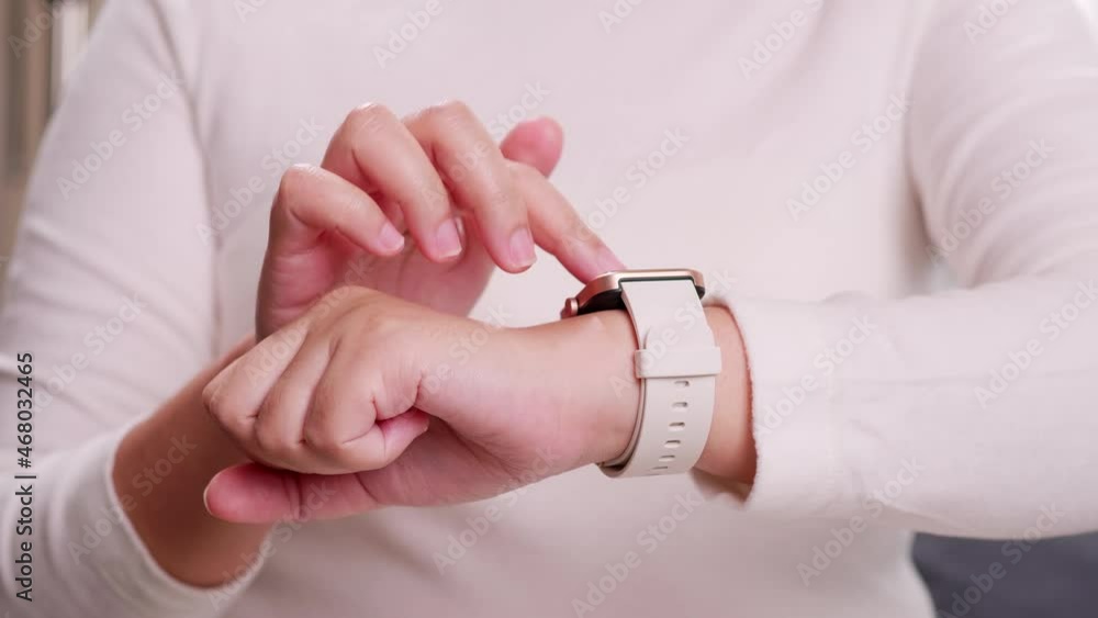 Aufkleber close up shot of a woman hand who touch and scrolling on a smartwatch in order to quickly check appl