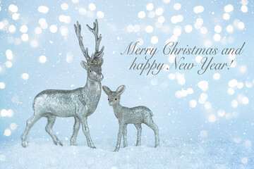 Christmas greeting card with silver reindeers on light bokeh background