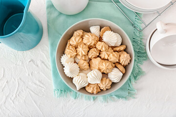 Bowl with tasty meringues on table