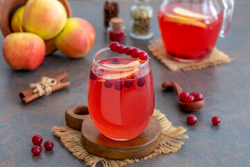 Glass of homemade cranberry apple punch with fresh berries, аpples, cinnamon and spices on table. Selective focus. © Iryna
