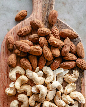 Almonds and cashew nuts on a wooden chopping board