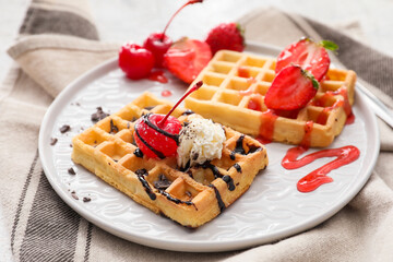Plate of tasty Belgian Waffles with berries on table
