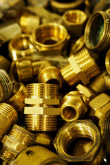 Brass fittings and couplings side by side on a pile.