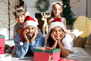 Obraz na płótnie Canvas Happy family with cute little children celebrating Christmas at home