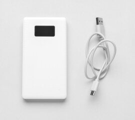 Obraz na płótnie Canvas Modern power bank and USB cable on light background