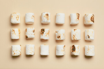 Tasty grilled marshmallows on beige background