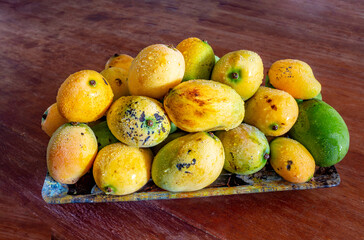 Naklejka na ściany i meble Mango sword ripe fruit wet on plate on table in selective focus .Common mango fruit