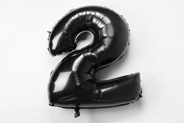 Black balloon in shape of figure 2 on white background
