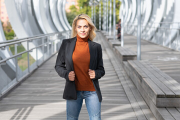 Woman in formal clothes facing the camera while standing in an urban street